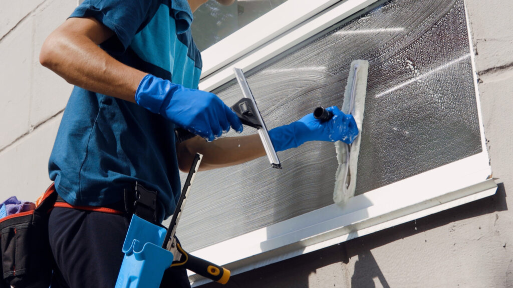 Schoonmaker of glazenwasser lapt ramen op locatie voor ISO 9001 kwaliteitsborging in de dienstverlening